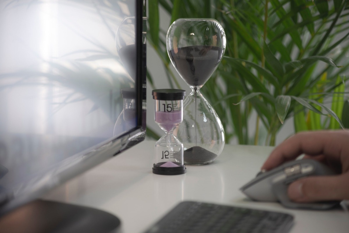 An hour glass in front of a computer monitor