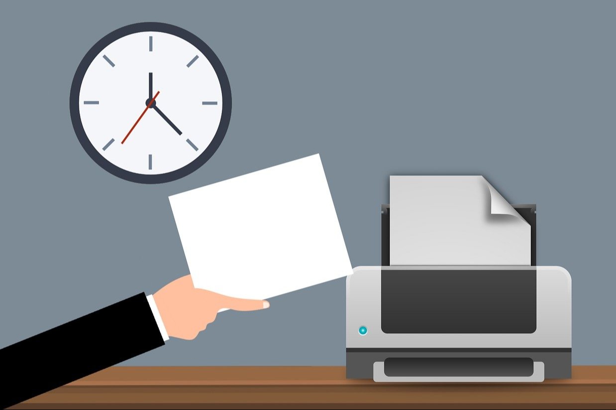 a hand placing paper into a printer