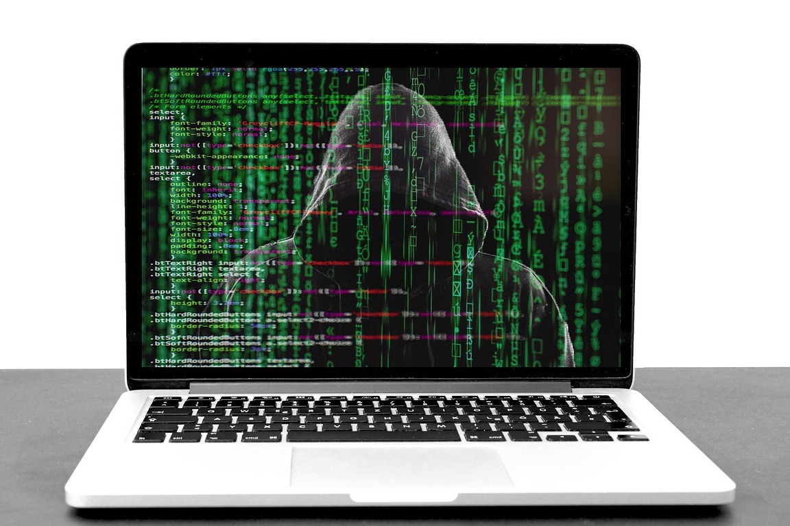 A hacker hiding in code on a computer screen
