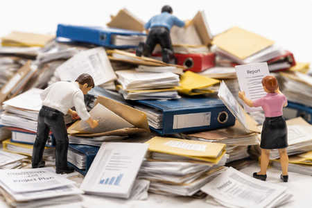 Miniature plastic people searching through files-1